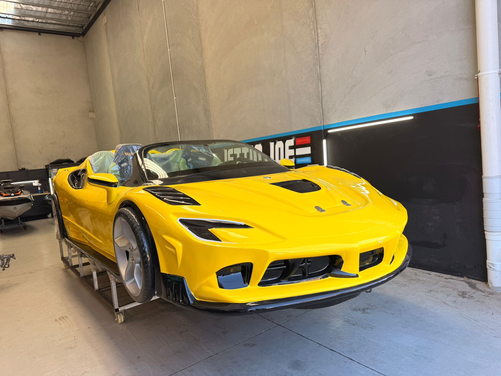 Hyper-detailed luxury jet car boat exterior, exotic supercar body lines, forged carbon fiber accents, glossy obsidian paint with electric blue underglow, studio lighting on black, automotive design showcase, photorealistic, 8K